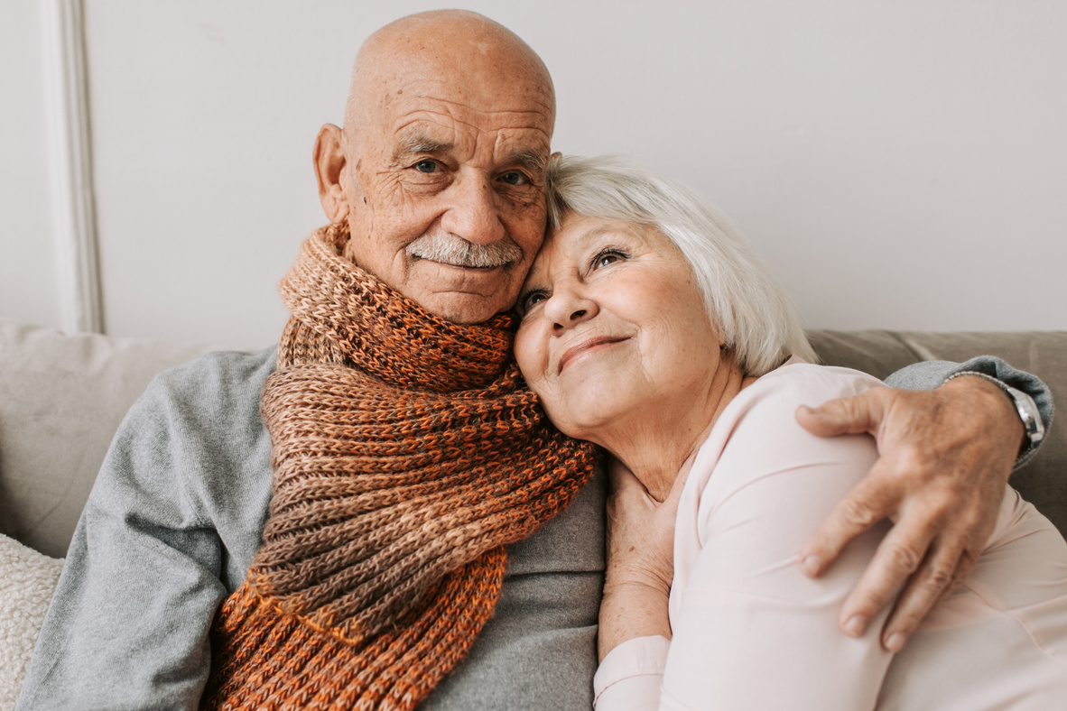 Man in Gray Sweater Hugging Woman in White Shirt